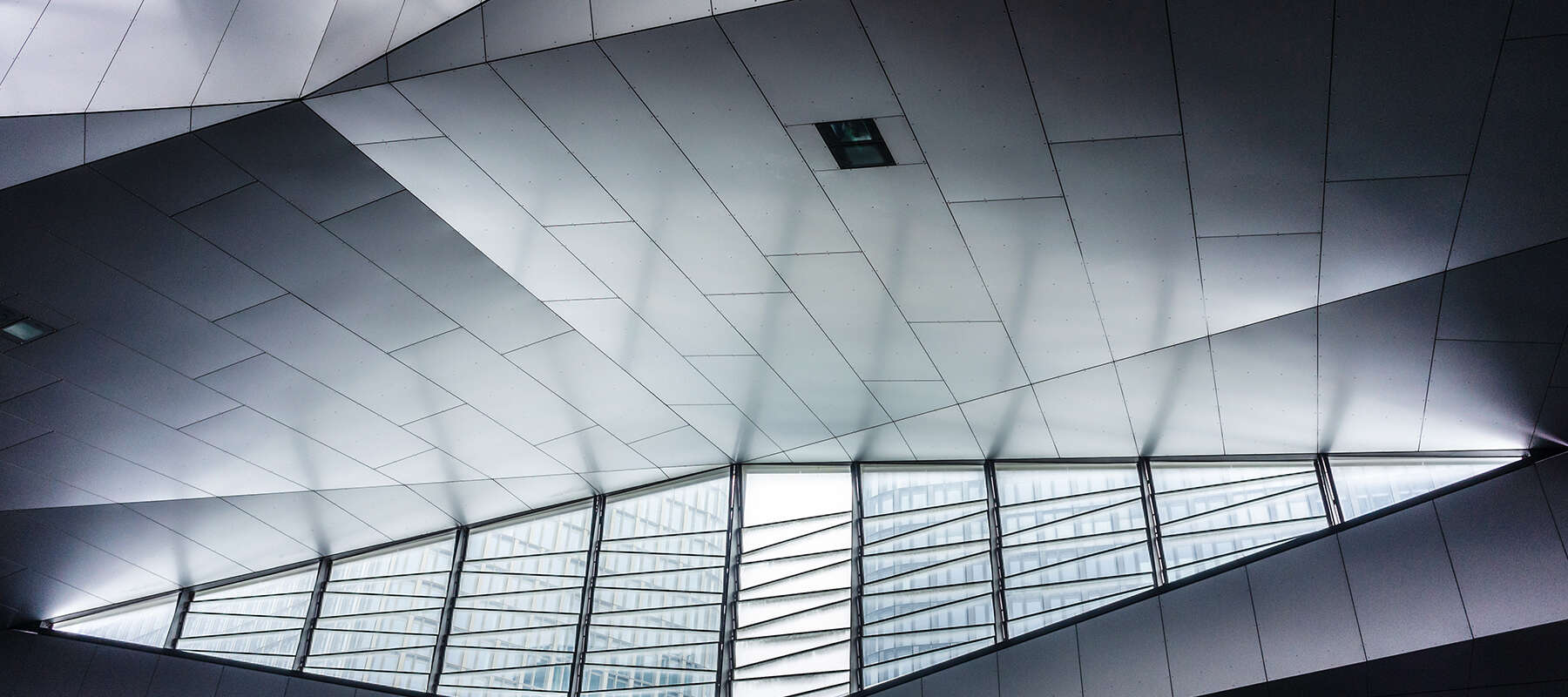 Modern geometric ceiling with large windows.